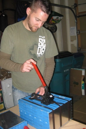 A man strapping together EV batteries